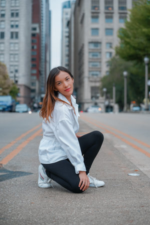 A stylish young beautiful Hispanic female posing on the road