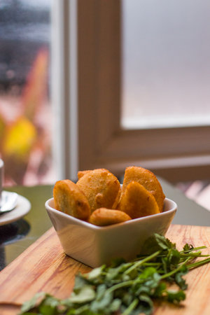 A soft focus of a bowl of empanada on a wooden boardの写真素材
