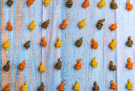 A top view of colored spiral pasta set up in lines on the blue wooden surfaceの写真素材