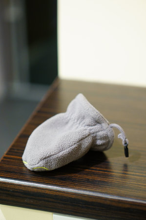 A vertical shot of a small pouch on a wooden tableの写真素材