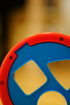 An early educational toy with geometric holes in the blurred background