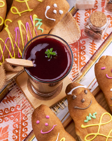 A top view of several cookies decorated as people and a bowl of jam in the middle