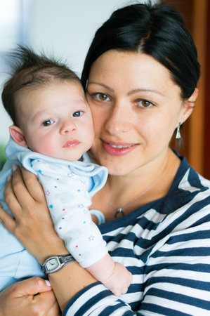 A close up of a mother hugging the cute baby daughter with loveの写真素材