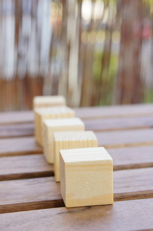 Five wooden cubes arranged on the table; shallow focus depthの写真素材
