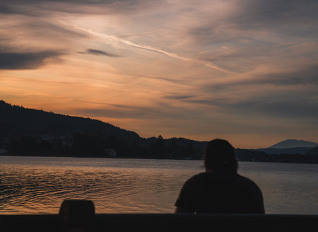 A man sitting near the sea during the sunset