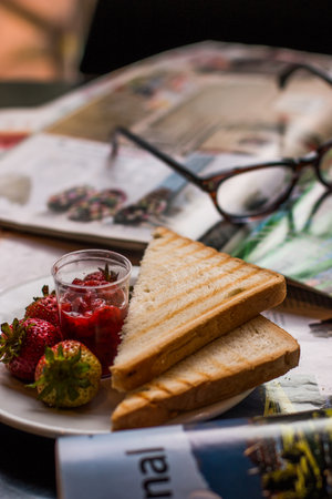 A breakfast plate at a restaurant with fresh strawberries and toastの写真素材