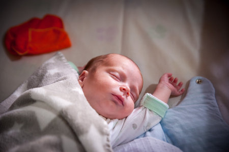 A closeup of an adorable little baby sleeping peacefully, wrapped in warm blankets