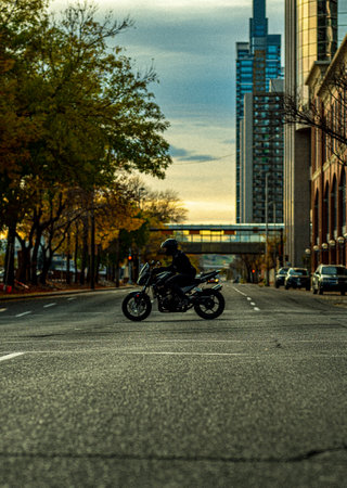 A motorcyclist rides through an intersection downtown Calgary, Albertaの写真素材