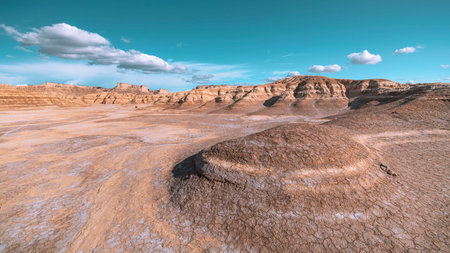 A landscape view of Bardenas Reales semi-desert with rock formations under a blue cloudy skyの写真素材