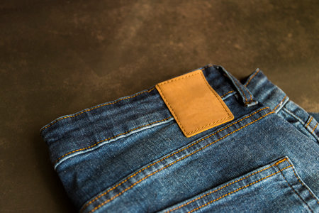An empty blank brown leather label on blue denim jeans