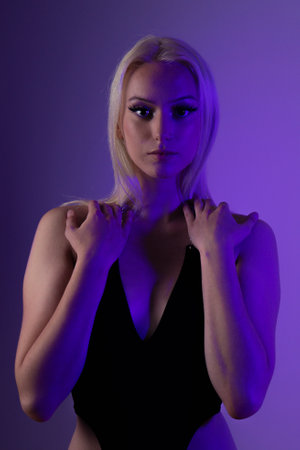 A portrait of a sexy Canadian woman with platinum blonde hair wearing a black swimsuit and posing in a studioの写真素材