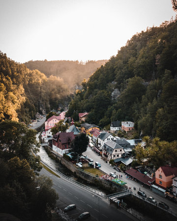 A vertical shot of rural buildings on roadsides surrounded by hills and treesの写真素材