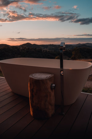 A vertical shot of bathtub outdoors with sunset backgroundの写真素材