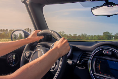 Woman driving cabriolet in the summer on the road
