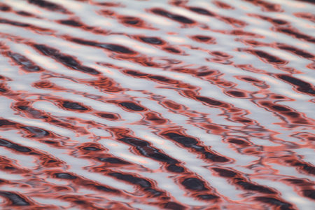 Light from sunrise reflecting off ripples, making an abstract pattern of multi-coloured rings and shapes arranged linearly. Malta, Mediterranean.の写真素材