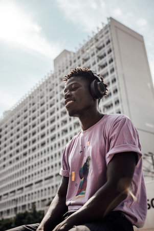 A black male model wearing headphones and enjoying music in Berlin, Germany