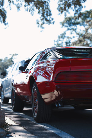 A rear view of a red car parked on the sidewalkの写真素材