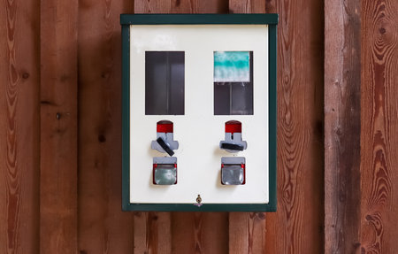 An old gumball machine for children on a wooden wall