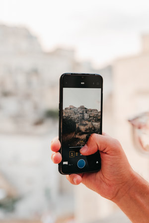 A man taking pictures of old architecture with his mobile phoneの写真素材