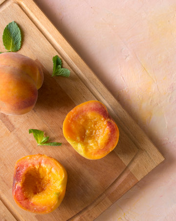 Half peaches ready to roasted on a peachy-colored backdrop.の写真素材