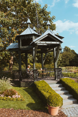 A vertical shot of a gazebo in the beautiful green park under a clear skyの写真素材