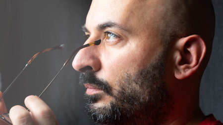 A middle-aged man putting on his new glasses for hypermetropia and astigmatism vision problemの写真素材