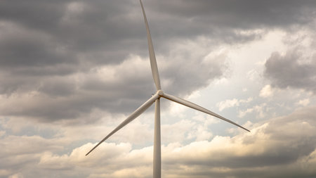 A wind turbine under a cloudy sky while driving through Texas