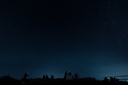 A Beautiful scenery of dark sky with stars over silhouette peopleの写真素材