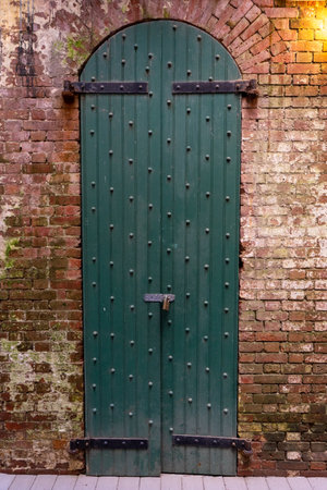 An old style green door of a brick wall buildingの写真素材