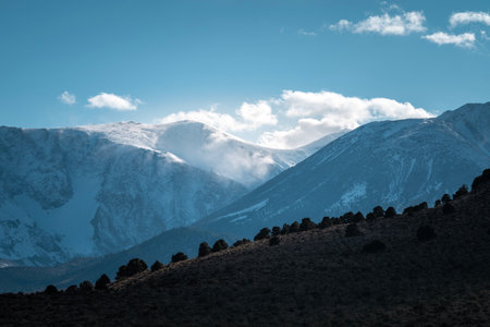A beautiful view of snowy mountains against a cloudy skyの写真素材