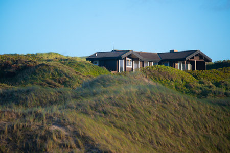 An exterior view of a summer house in Denmark near the North Sea under a blue skyの写真素材