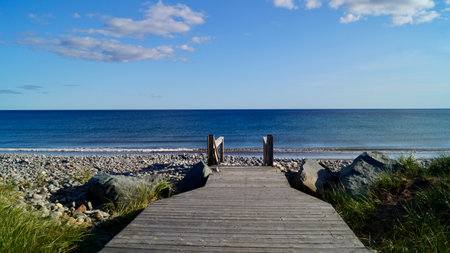 A view of a pier and a calm sea on a sunny dayの写真素材
