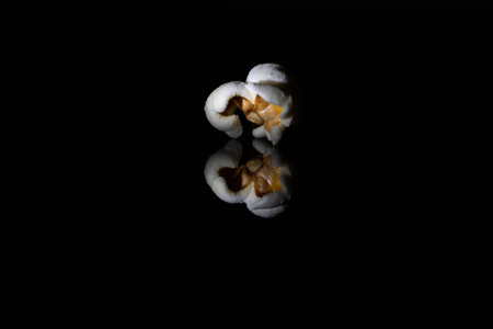 A single popcorn isolated on a black backgroundの写真素材