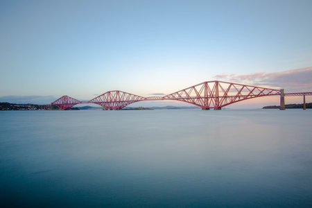 A beautiful view of the Forth Bridge (railway) on the river with cloudy sky in South UK