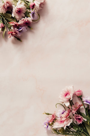 A vertical shot of beautiful flowers on the pink background and a space for your textの写真素材