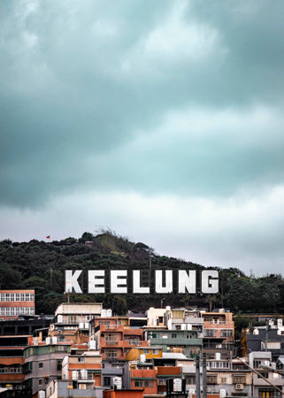 A vertical shot of a large Keelung sign above old houses on a hill in Taiwanの写真素材