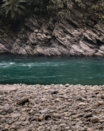 A vertical shot of a flowing river and stonesの写真素材