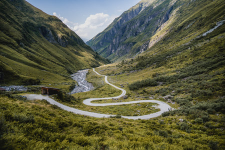 A beautiful view of a flowing thin stream through green mountains in the Austrian Alps