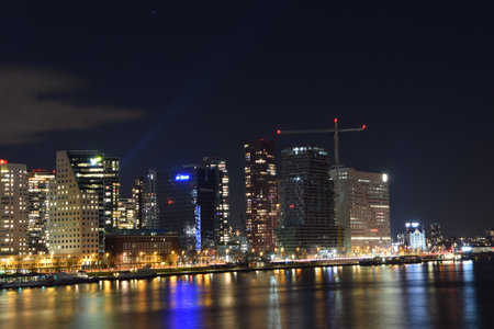 A view of a city with lights in front of the water at nightの写真素材