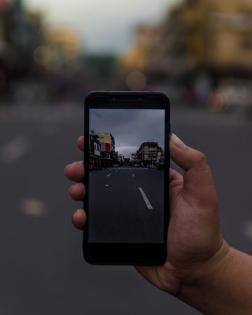 A closeup shot of a person taking a photo of a streetの写真素材