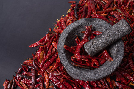 A closeup of dried red chili with mortar and pestle.の写真素材