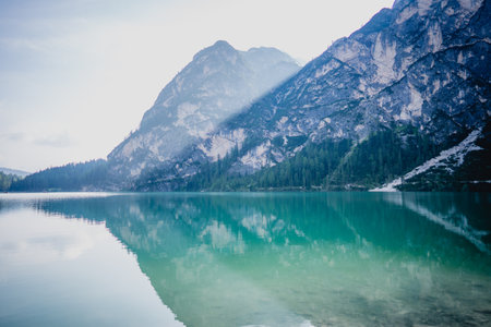 A beautiful blue icy lake near snowy cliffs in Italyの写真素材