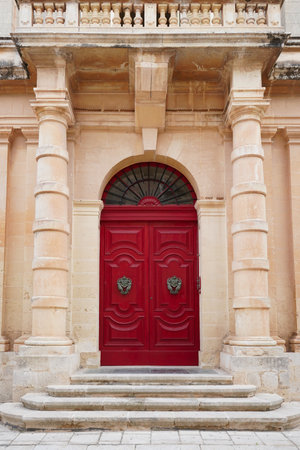 A vertical shot of a red door of a building in Mdina, Maltaの写真素材