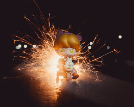 The toy boy character on the tricycle with bright sparks and bokeh lights in the backgroundの写真素材