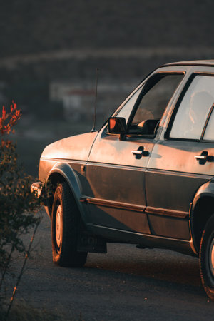 A closeup shot of a parked car outdoors during the sunset
