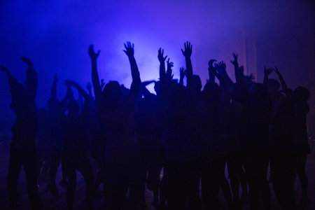 A group of people dancing with their hands up during the partyの写真素材