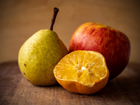 A closeup of still life with pear, half-cut orange, and appleの写真素材