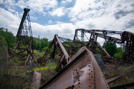The collapsed Kinzua bridge amid dense vegetation against a cloudy sky in State Park Mount in USAの写真素材