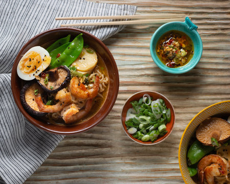 A top view of ramen bowl with an egg, mushroom, shrimp and other ingredientsの写真素材