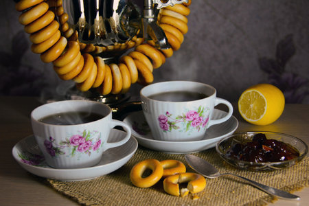 Two cups of hot tea from a samovar with bagelsの写真素材